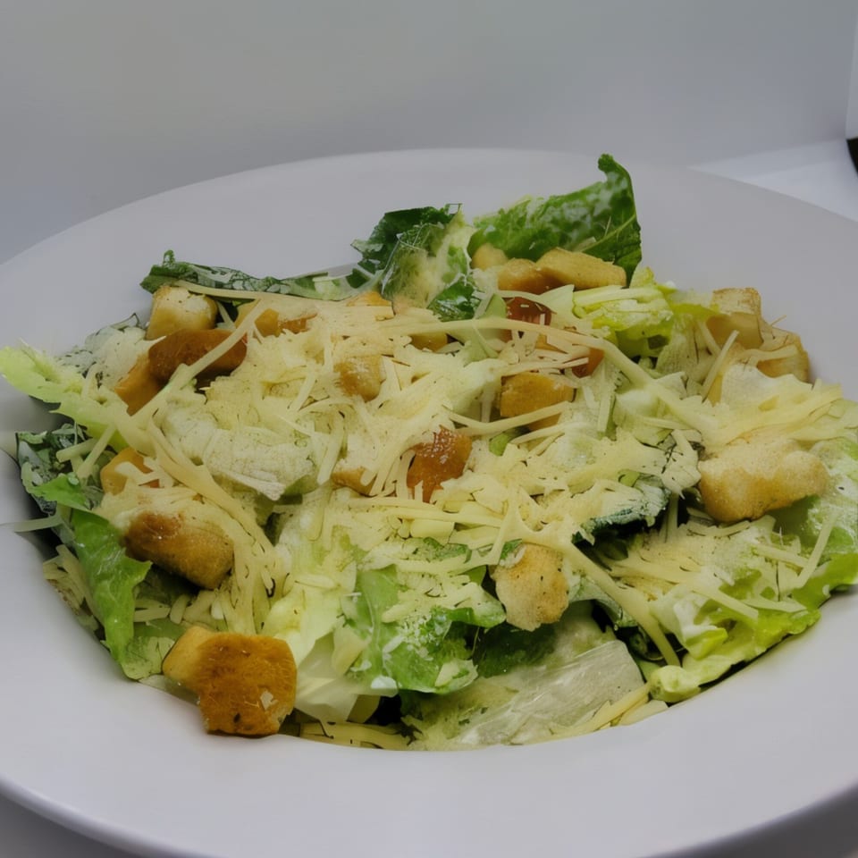 A Caesar salad with crisp romaine lettuce, croutons, and shredded Parmesan cheese in a white bowl.